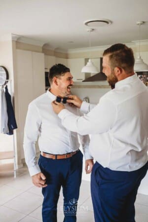 Gledswood Wedding - Groom prep groomsman attached the grooms tie