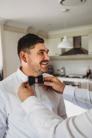 Gledswood Wedding - Groom prep groomsman attached the grooms tie