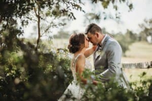 Gledswood Wedding - a bride and groom hug in the gardens at the venue