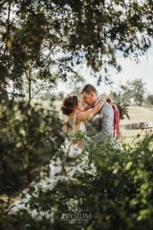 Gledswood Wedding - a bride and groom hug in the gardens at the venue