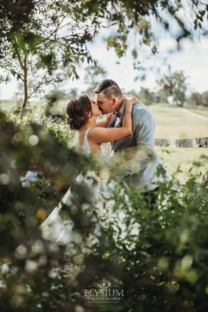 Gledswood Wedding - a bride and groom kiss in the gardens at the venue