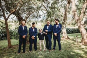 Gledswood Wedding - groomsmen stand in the gardens at the venue