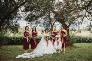 Gledswood Wedding - a bride stands with her bridesmaids in the gardens at the venue