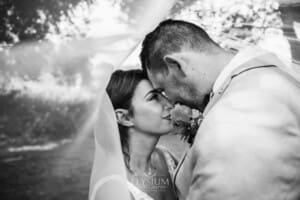 Gledswood Wedding - a bride and groom hug standing under the bride's veil