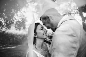 Gledswood Wedding - a bride and groom hug standing under the bride's veil