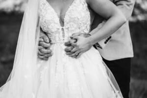 Gledswood Wedding - a bride and groom hug standing in the gardens at the venue