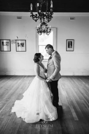 Gledswood Wedding - a bride and groom stand in the music room at their reception venue