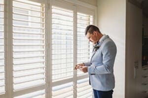 Gledswood Wedding - Groom stands next to a bright window during morning prep