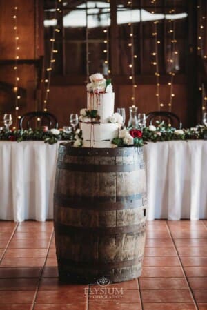 Gledswood Wedding - wedding cake sits on a wine barrel in the reception venue