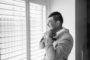 Gledswood Wedding - the Groom adjusts his tie during morning prep