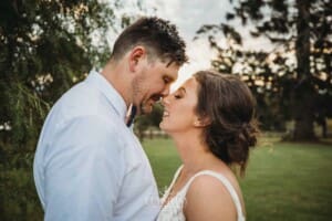 Gledswood Wedding - a bride and groom stand facing each other at sunset