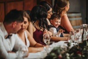 Gledswood Wedding - a little boy giggles while sitting on a bridesmaid's lap at the reception