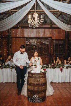 Gledswood Wedding - a bride and groom cut the wedding cake at the reception
