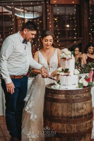 Gledswood Wedding - a bride and groom cut the wedding cake at the reception