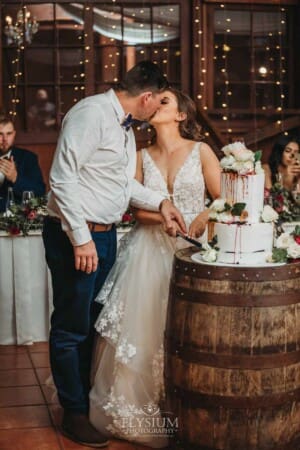 Gledswood Wedding - a bride and groom cut the wedding cake at the reception