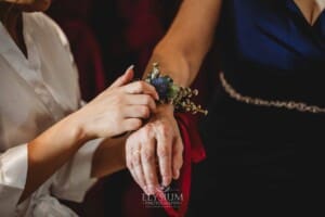 Gledswood Wedding - a bride attaches her mother's flower wrist band