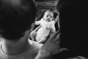 A newborn baby held in her parents arms