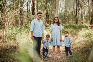 Family Session - Parents stand on a path holding their children's hands