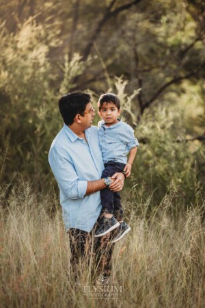 Family Session - A father holds his little boy standing in long grassy