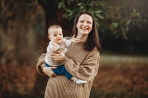 Baby photography - a mother cuddles her baby girl in a park