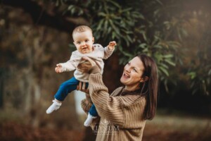 Baby photography - A mother lifts her happy baby girl above her