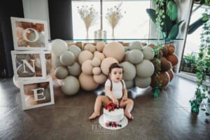 Cake Smash Photographer: a baby boy touches the icing and berries on his cake