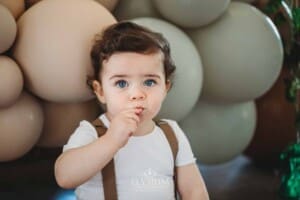 Cake Smash Photographer: a baby boy eats the berries on his cake