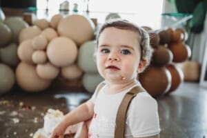 Cake Smash Photographer: a baby boy sits covered in icing