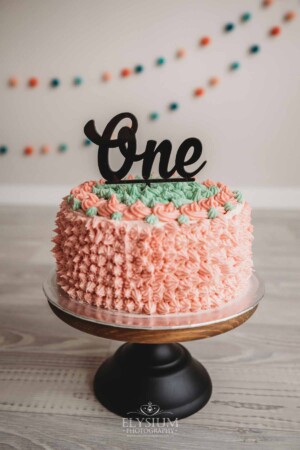 Baby Cake smash Photography: A first birthday cake decorated with pink and green icing