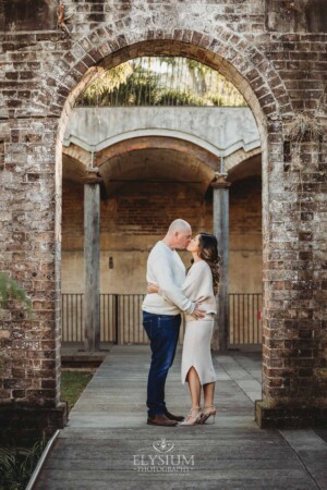 Sydney Family Photographer: a couple kiss under a rustic brick arch