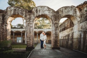 Sydney Family Photographer: a couple cuddle under a rustic brick arch