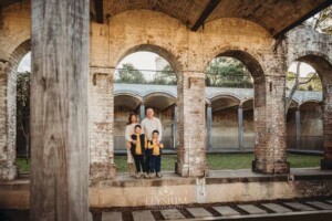 Family Photographer: A family stand on an old stone wall in Paddington Reservoir Gardens