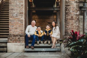 Sydney Family Photographer: parents sit with their sons under a rustic brick arch