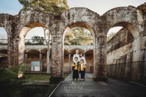Sydney Family Photographer: parents cuddle their boys under a rustic brick arch
