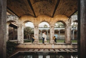 Sydney Family Photographer: parents kiss as their kids giggle under a rustic brick arch