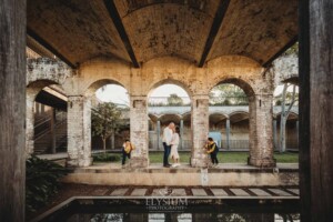 Sydney Family Photographer: parents kiss as their kids giggle under a rustic brick arch