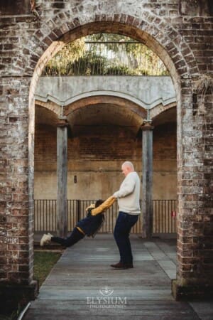 Sydney Family Photographer: dad spins his son around under a rustic brick arch