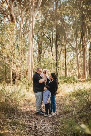 Family Photography: parents cuddle their babies on a bushy path at sunset