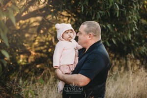 Family Photography: a father cuddles his baby girl at sunset