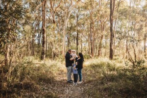 Family Photography: parents cuddle their babies on a bushy path at sunset