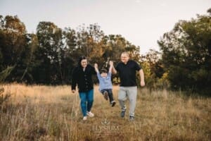 Family Photography: parents walk swinging their little boy between them