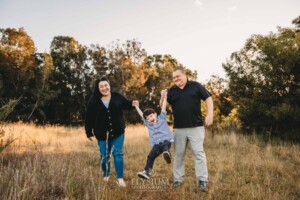 Family Photography: parents walk swinging their little boy between them