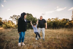 Family Photography: parents walk swinging their little boy between them