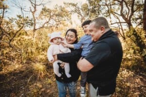 Family Photography: parents cuddle their babies on a bushy path at sunset