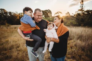 Family Photography: parents cuddle their babies in a grassy field