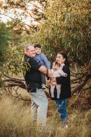 Family Photography: parents cuddle their kids under a tree