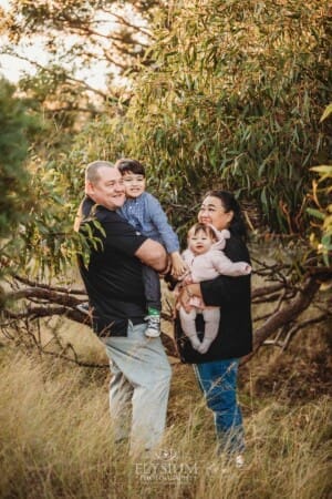 Family Photography: parents cuddle their kids under a tree