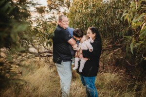 Family Photography: parents cuddle their kids under a tree