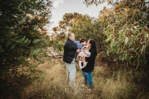 Family Photography: parents cuddle their kids under a tree