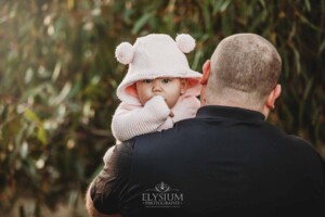 Family Photography: a father cuddles his baby girl on his shoulder